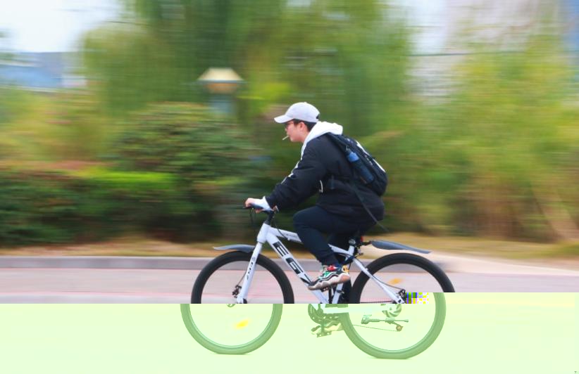 男人騎着自行車在路上描述已自動生成